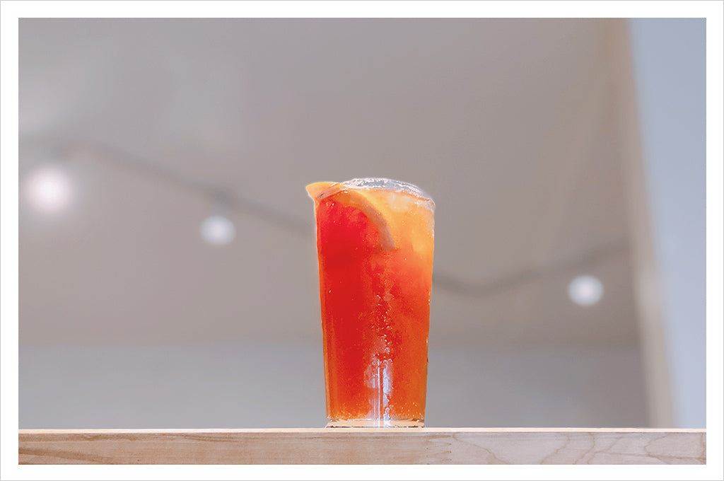 the orange colored paloma cocktail in a glass