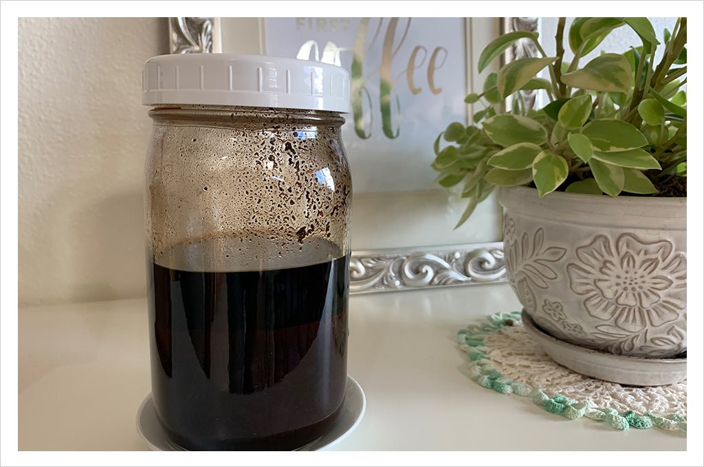a jar of coffee liqueur next to a plant in white pot