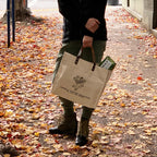 a person holding a beige logo tote on the street